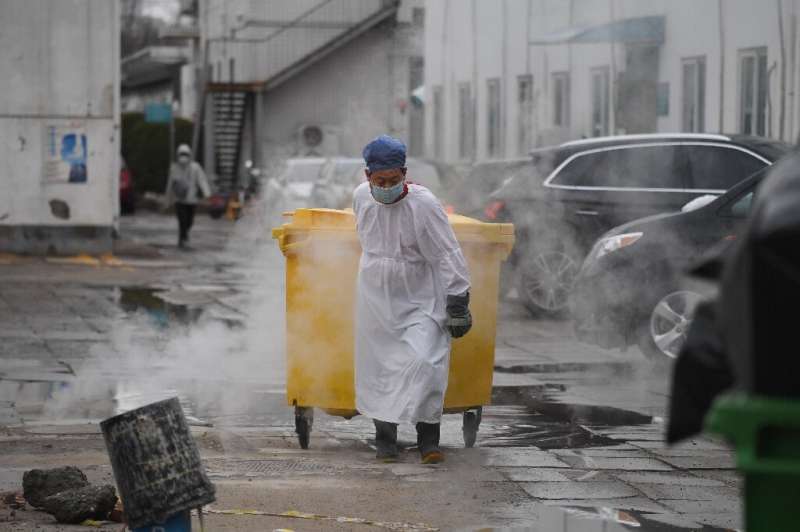 一个工人移动医疗废物在北京一家医院治疗冠状病毒患者