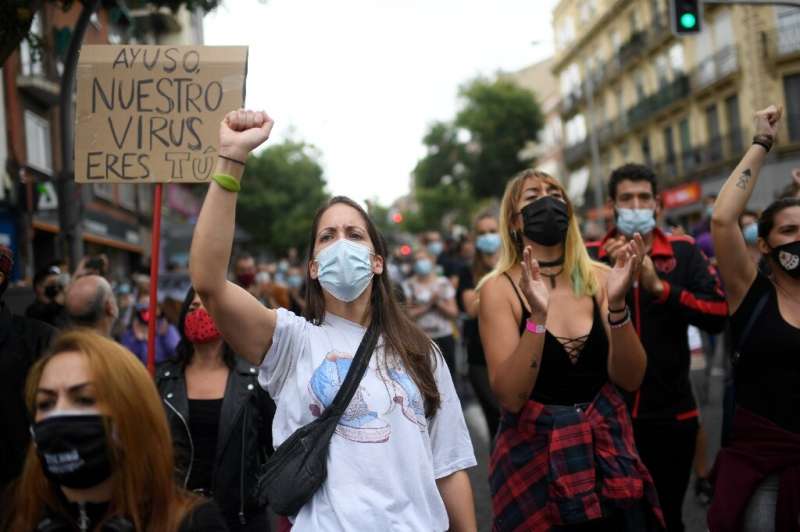 People attend a demonstration at the Vallecas neighborhood in Madrid to protest new restrictive measures announced by regional a