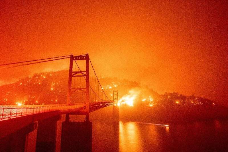 The Bidwell Bar Bridge is surrounded by fire in Lake Oroville during the Bear Fire in Oroville, California