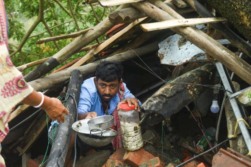 Villagers salvage items from their houses damaged by Cyclone Amphan in the Indian state of West Bengal