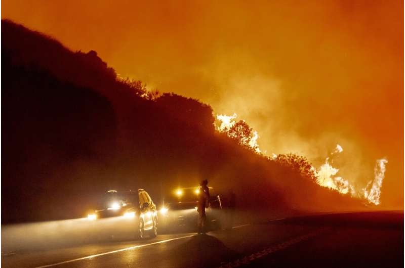 Californians flee as strong winds push fire through canyons