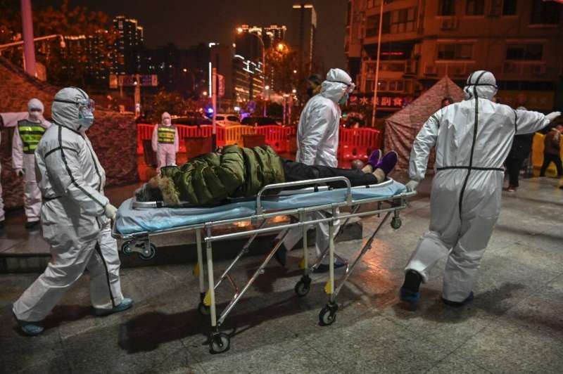 Medical staff in protective clothing arrive with a patient at a hospital in Wuhan on January 25, 2020