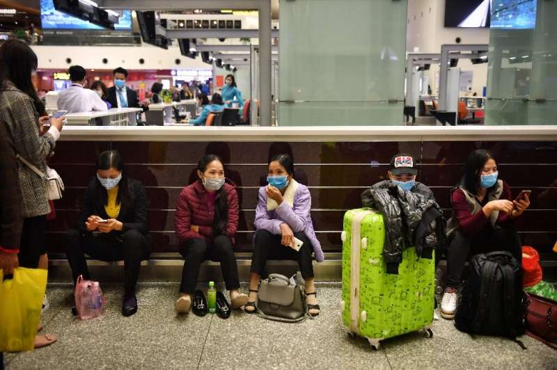 Passengers wear protective face masks in the departure hall of Noi Bai International Airport in Hanoi, Vietnam, which shares a l