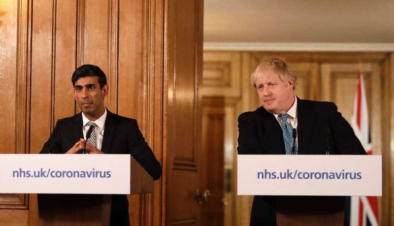 Prime Minister Boris Johnson (R) said Britain needed to act &quot;like any wartime government,&quot; as finance minister Rishi S