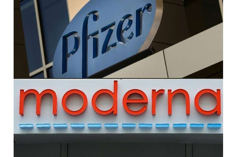 This combination of file pictures shows signs for the Pfizer and Moderna pharmaceutical companies, both in Cambridge, Massachuse