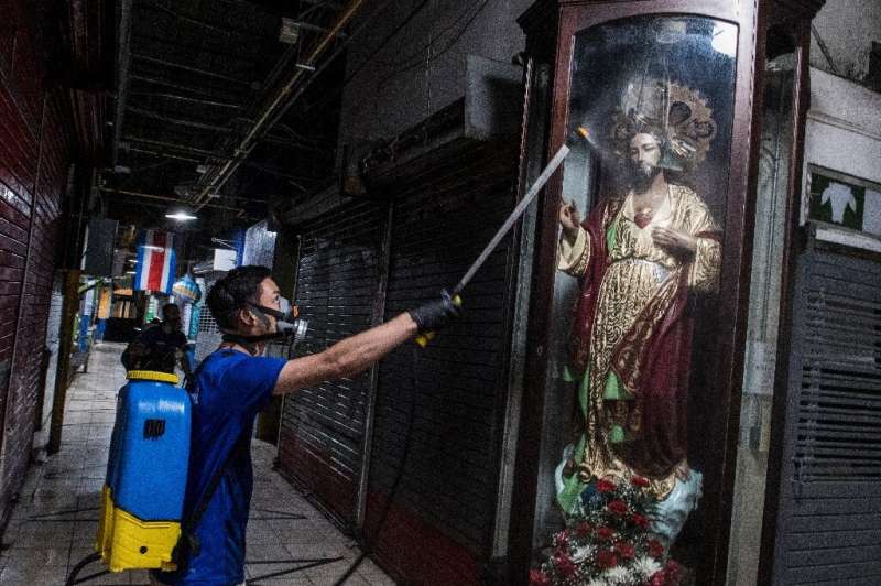 A worker disinfects the central market in San Jose, Costa Rica