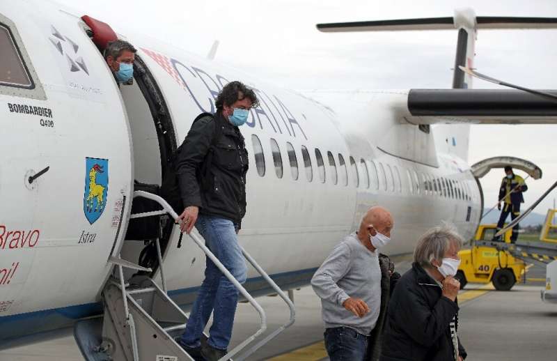 Passengers wearing masks get off a plane at Zagreb International Airport Croatia, on May 11, 2020