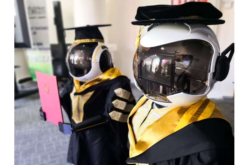 This handout photo released by the Sultan Zainal Abidin University shows two robots wearing graduation robes during a simulation