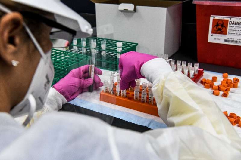 A lab technician sorts blood samples inside a lab for a Covid-19 vaccine study at the Research Centers of America (RCA) in Holly