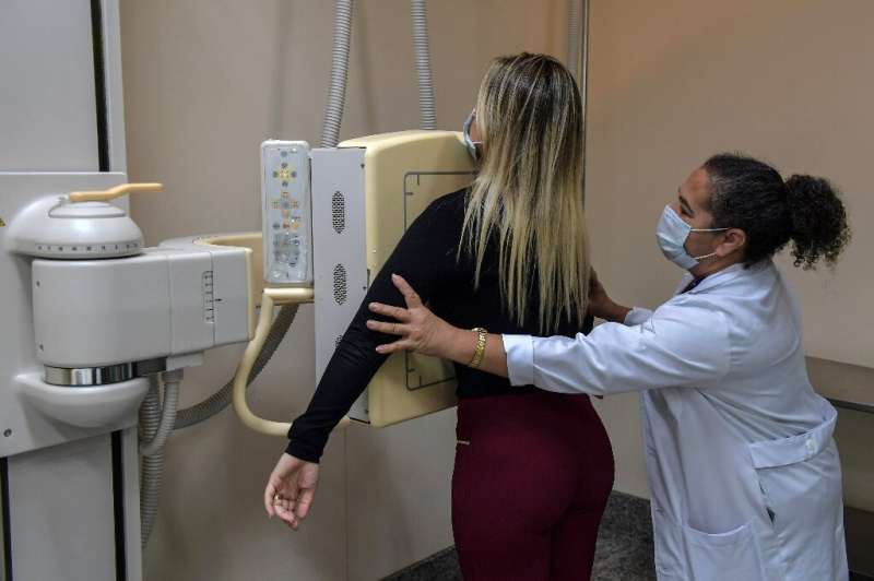 A medical worker puts a patient in position for a chest x-ray at the University of Sao Paulo Clinical Hospital
