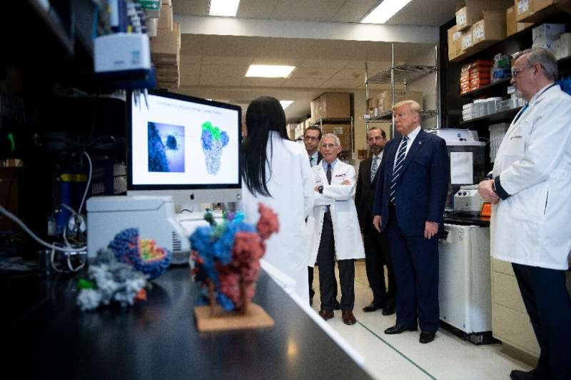 President Donald Trump tours the National Institutes of Health's Vaccine Research Center in Bethesda, Maryland, as the death tol