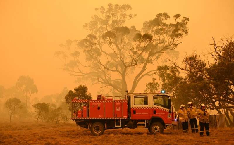 Firefighters protect a property from bushfires burning near the town of Bumbalong south of Canberra on February 1, 2020