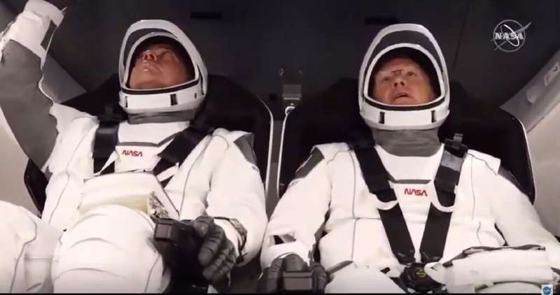 NASA astronauts Bob Behnken (L) and Doug Hurley (R) are strapped in the SpaceX Crew Dragon capsule