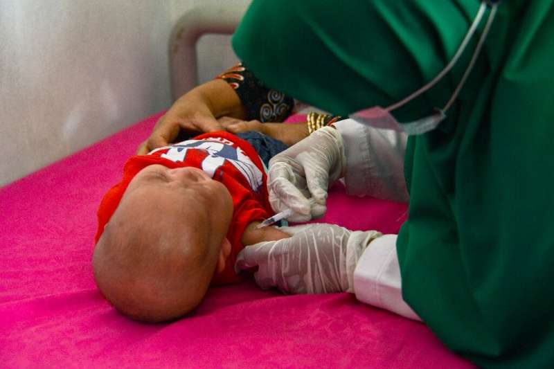 A baby receives the Bacillus Calmette–Guerin (BCG) vaccine for tuberculosis at an integrated services post in Banda Aceh, Indone