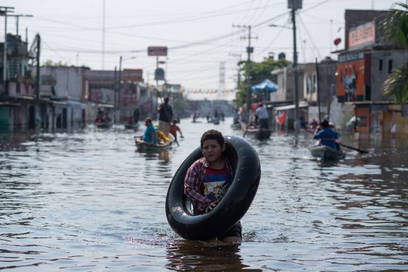 A boy wades through a flooded street in the Mexican city of Villahermosa. Thousands of people in Tabasco state have been forced 