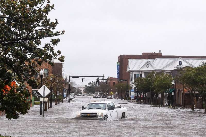 A city worker drives through a flooded street in Pensacola, Florida, after Hurricane Sally