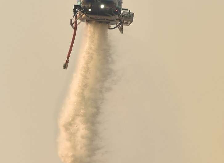 A helicopter drops water on a bushfire in Batemans Bay in New South Wales