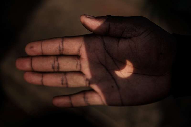 A Kenyan man projected the eclipse onto his hand through a pair of binoculars in Nairobi