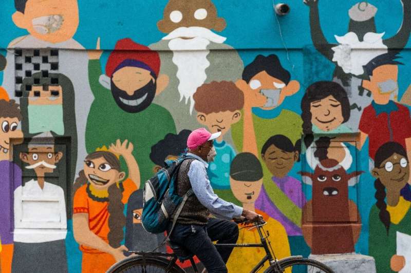 A man in a coronavirus mask rides along a street in New Delhi