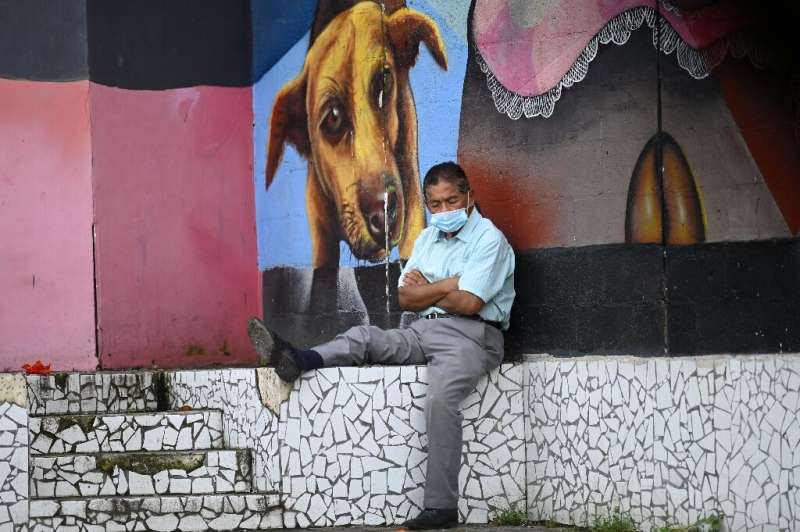 A man rests in a park after the government eased lockdown measures after five months of quarantine in San Salvador on August 24,