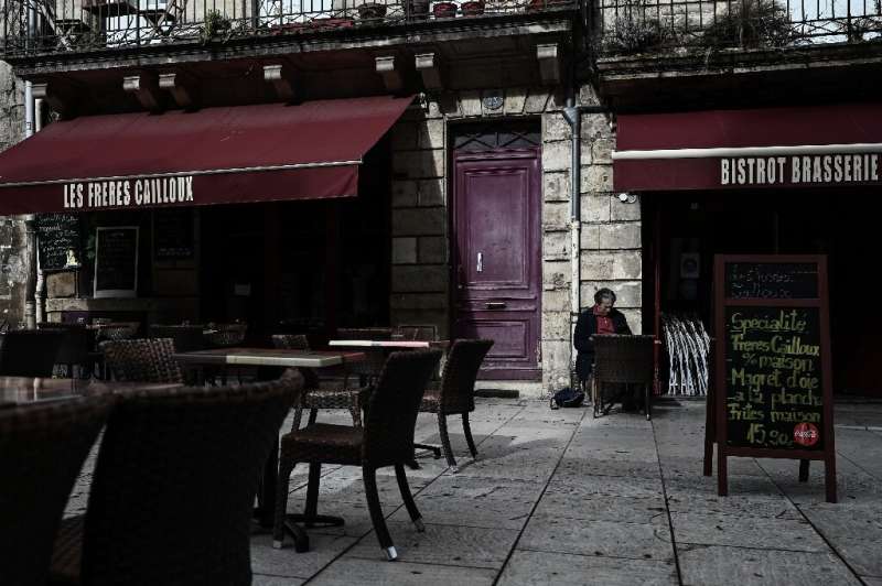 A man sits at an empty terrasse of a cafe in Bordeaux before a new Covid-19 lockdown comes into effect.