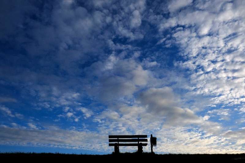 An empty bench silhouettes against the evening sky in Emden, northern Germany, as many activities slowed down or came to a halt 