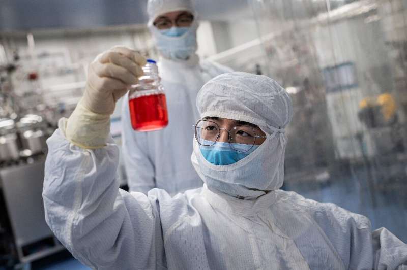 An engineer looks at monkey kidney cells used to test an experimental vaccine for the COVID-19 coronavirus in China, which has b