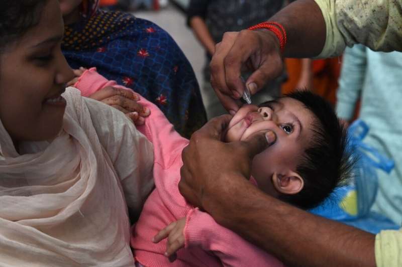 A Pakistani health worker administers polio drops to a child at a railway station during a polio vaccination campaign in Lahore 