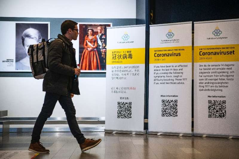 A passenger arriving in Stockholm's Arlanda airport is greeted by signs produced by the public health agency advising travelers 