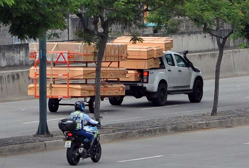 A pick-up truck carries coffins as its drives past the IESS Hospital Los Ceibos in Guayaquil, Ecuador