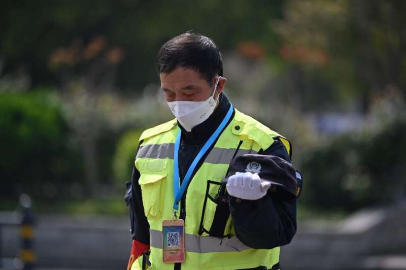 A policeman bows his head in Wuhan as China observed three minutes of silence to mourn those who died in the coronavirus pandemi