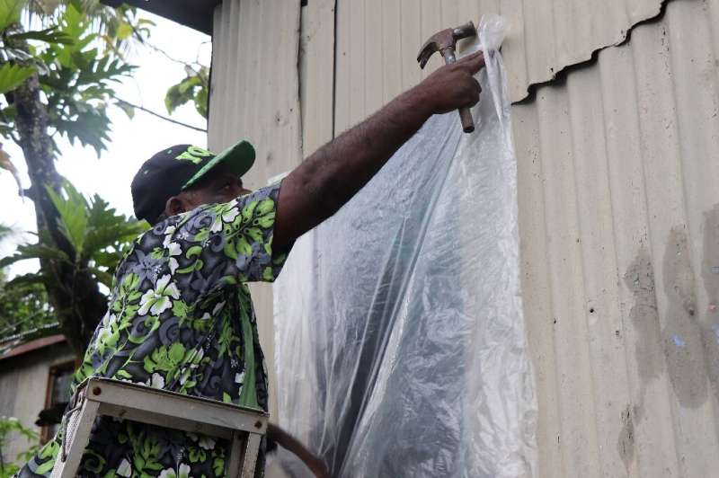 A resident of Fiji's capital Suva prepares his home for the arrival of super Cyclone Yasa