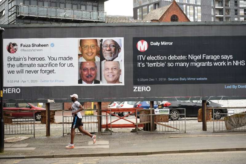 A runner passes posters critical of comments made about migrants in Manchester, north-west England