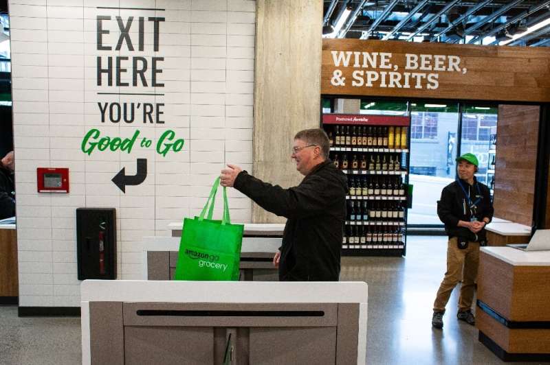 A shopper exits Amazon Go Grocery on February 26, 2020 in Seattle, Washington, the first full-sized retail grocery location that