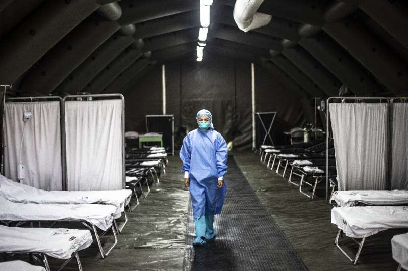 一名专家正在秘鲁卫生部设立的一个流动单位内行走，该单位是为了预防病毒在秘鲁肆虐