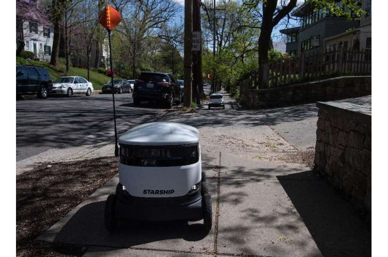A Starship delivery robot leaves the Broad Branch Market grocery store in Washington, DC, on its way to a home customer