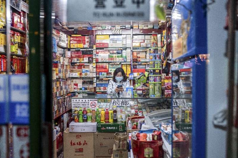 A vendor wearing a protective facemask waits for customers at a shop in Beijing
