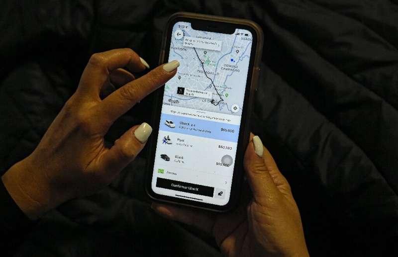 A woman checks the Uber transport application on her mobile phone after authorities ordered its suspension in Colombia, in Bogot