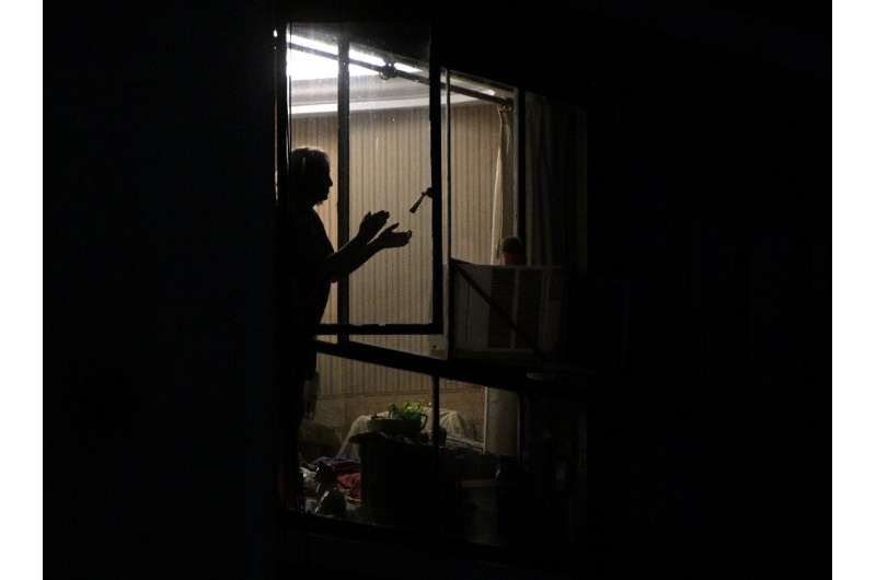 A woman in Buenos Aires, Argentina claps her hands to express gratitude to health workers, a nightly tradition during the &quot;