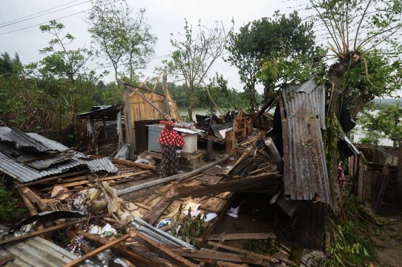 A woman looks at what is left of her home after Cyclone Amphan hit Satkhira district in Bangladesh