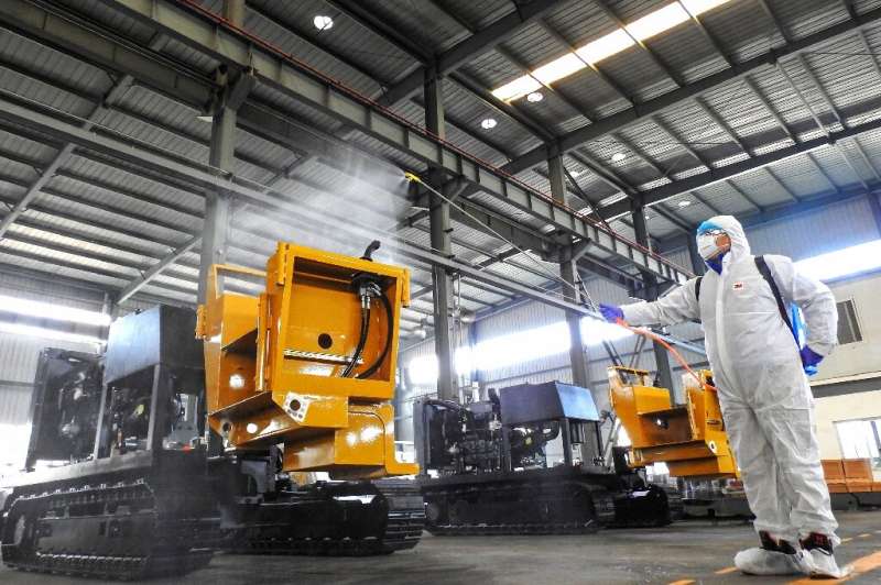 A worker disinfects machines before production resumes at a factory in Lianyungang in China's eastern Jiangsu province
