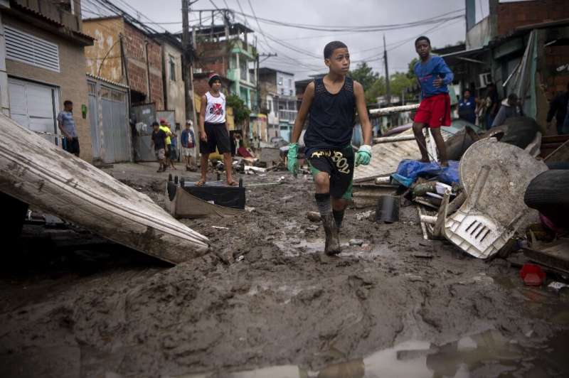 Children walk in the mud following heavy rains during the weekend, in Realengo neighborhood, in the suburbs of Rio de Janeiro, B