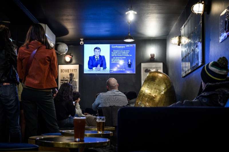 Clients watch Macron's evening televised address to the nation in a cafe in Bordeaux, which will have to close on Friday.