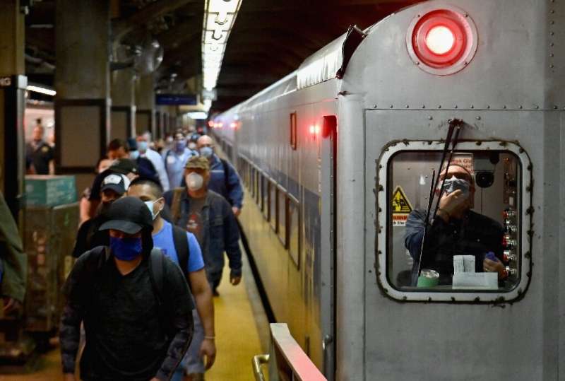 Commuters arrive at New York's Grand Central Station during morning rush hour as the city entered phase one of its coronavirus r
