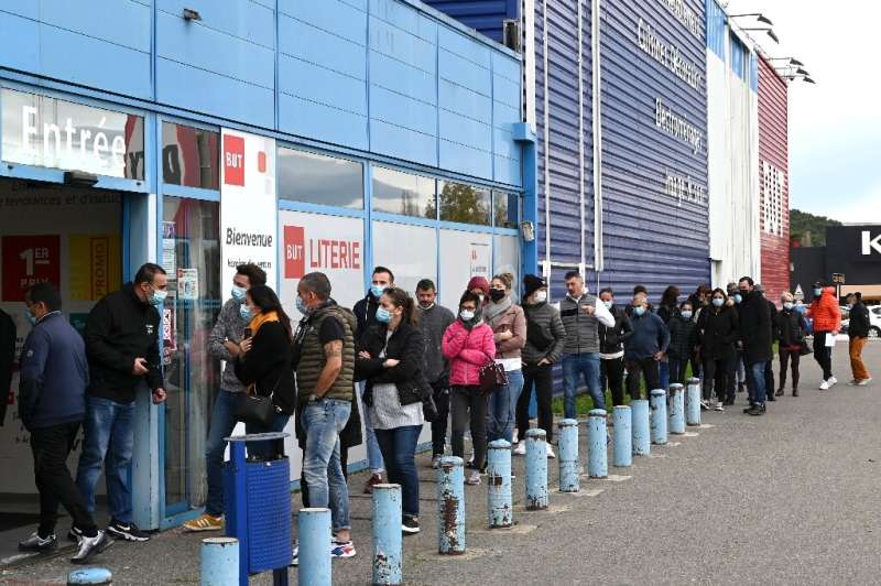 Customers queued outside a furniture store in southeastern France as shops were allowed to lift their shutters for the holiday s