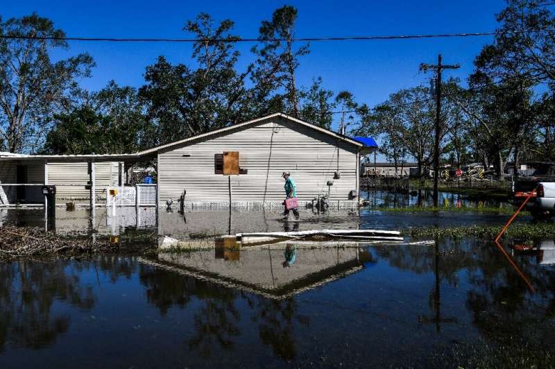 Daniel Schexnayder walks through his flooded yard in the small town of Iowa, Louisiana on October 10, 2020