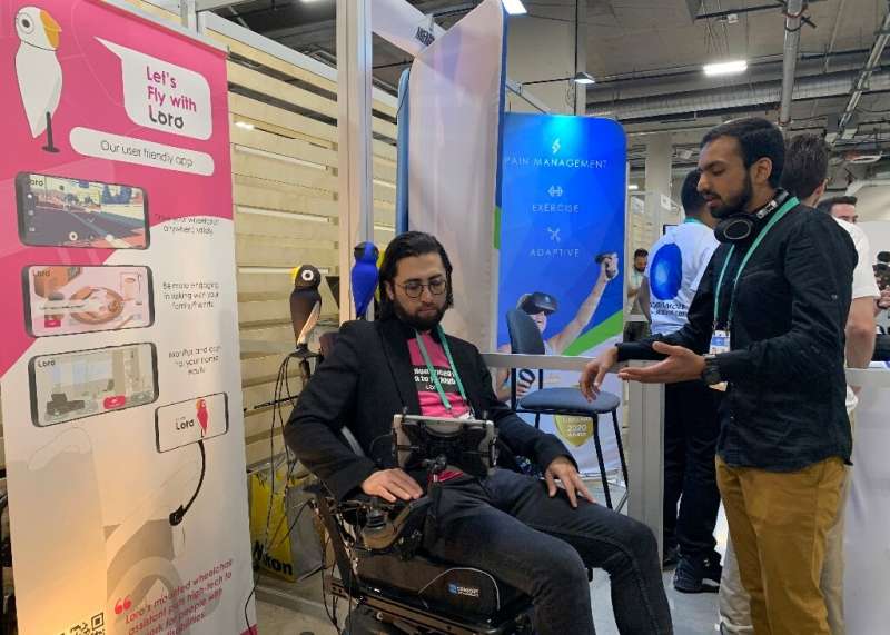 David Hojah (L), cofounder and CEO of Loro, shows the robot assistant for the wheelchair-bound at the 2020 Consumer Electronics 