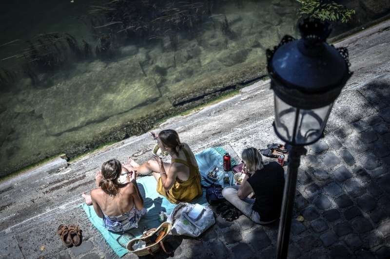 Europeans have thronged parks and rivers, as here on the banks of the River Seine in Paris, as the rising mercury announces the 