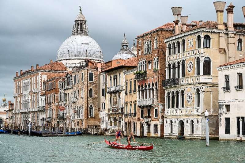 Gondoliers in Venice practise on the Grand Canal as they wait for tourists to return to the city