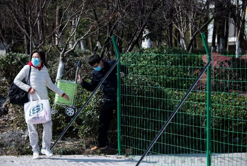 Green fences and &quot;no entry&quot; signs block streets near the headquarters of Alibaba, in a city hit by China's deadly vira